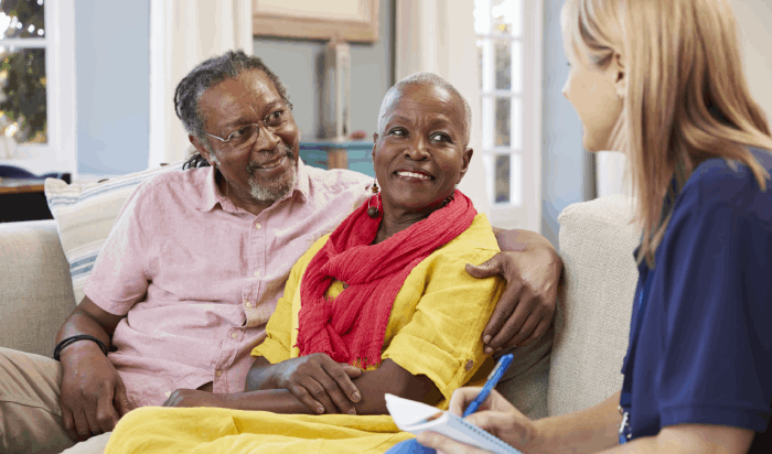 An African-American man and woman meeting with a social worker.