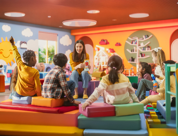 Cheerful Preschool Educator Playing and Creatively Studying with Multiethnic Kids in Kindergarten. Small Adorable Children Getting Basic Reading and Writing Skills, Learning Alphabet