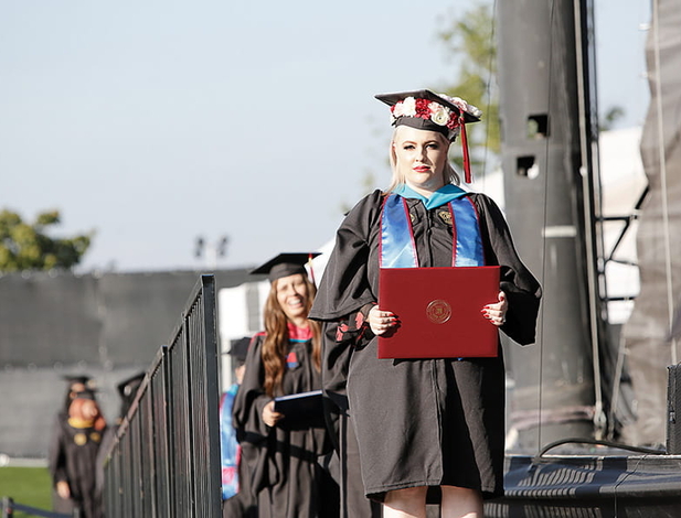 Umass Global Graduate Walking On Stage