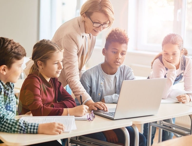 older female teacher who has her credential teaching a group of older elementary school children
